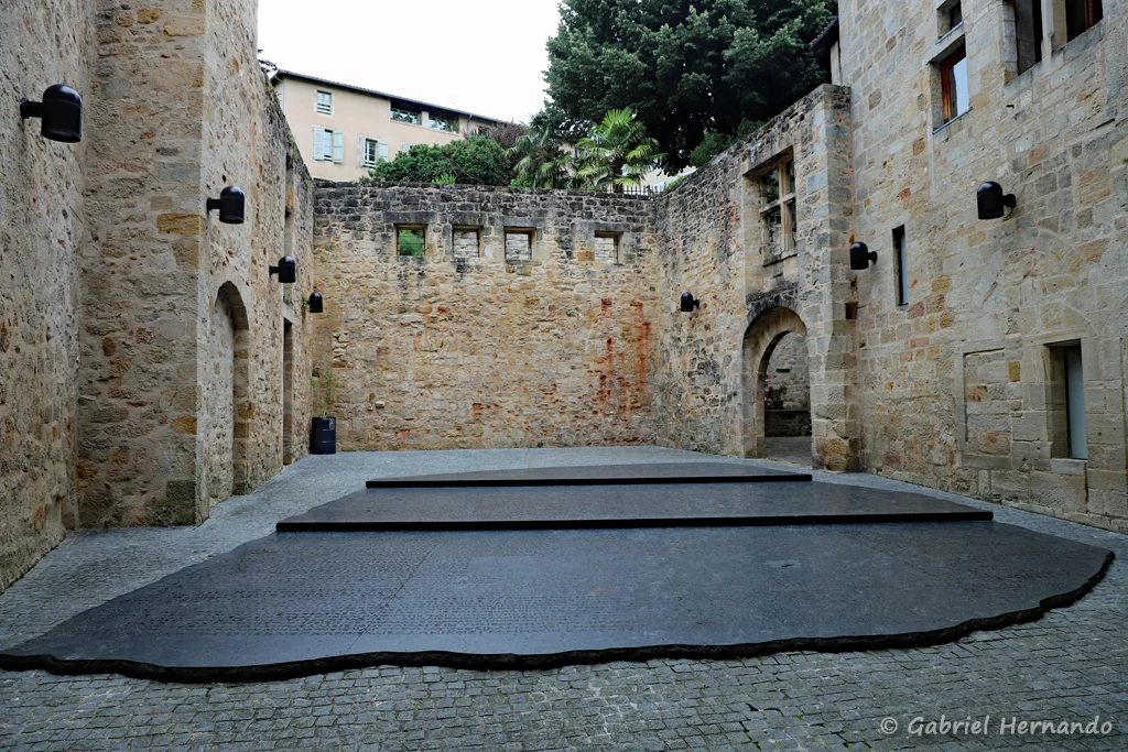 Place des écritures, site emblématique de la ville, au centre d'un cour médiévale, avec la reproduction de la pierre de Rosette (Figeac, juin 2022)