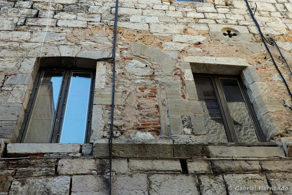 Vestiges de fenêtres géminée et d'un cordon sculpté, de la maison de Consul (XIIIe siècle), au milieu de la rue de la Peyre (Cajarc, juillet 2022)
